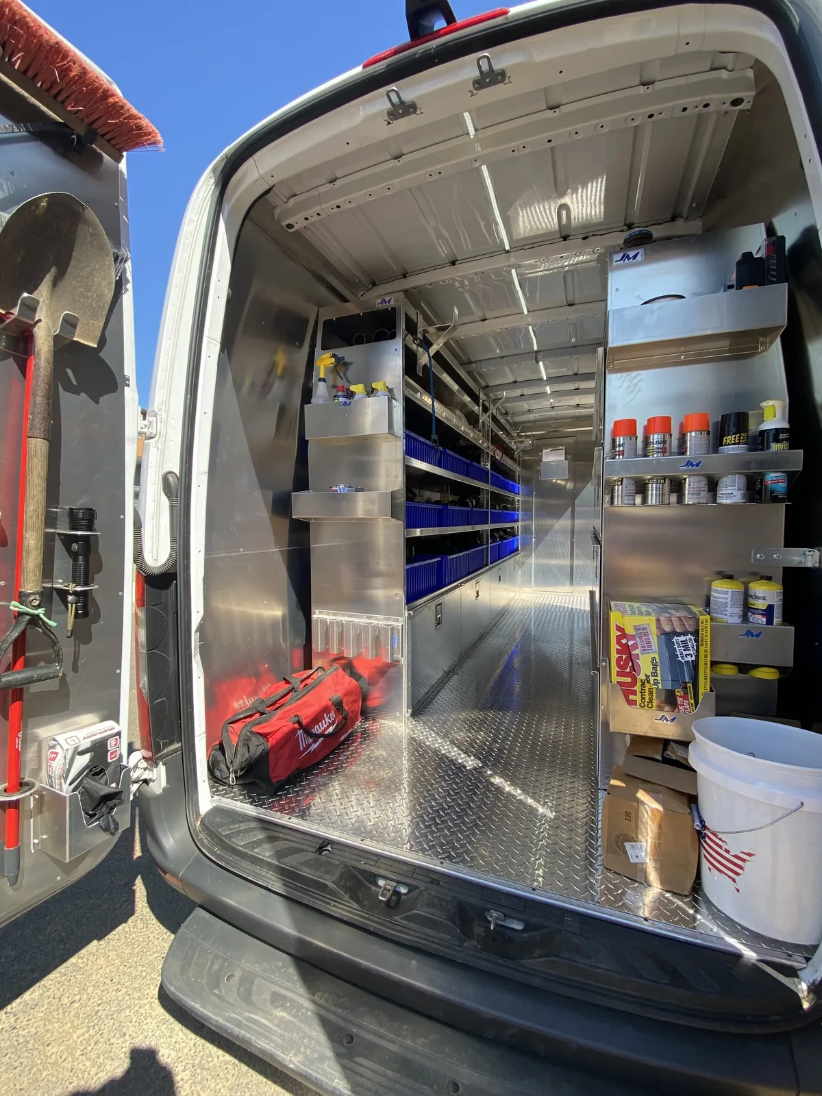 Inside a Panda Plumbing van with organized shelving and labeled parts bins