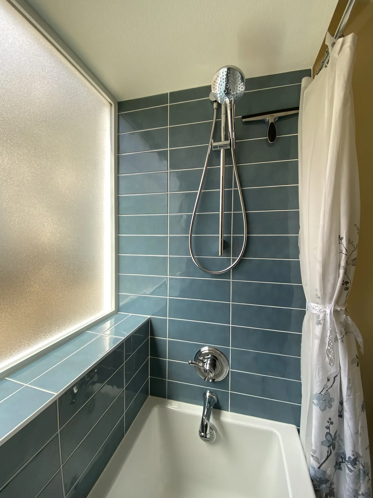 Tub and shower combo in slate blue stacked tile with chrome hand shower