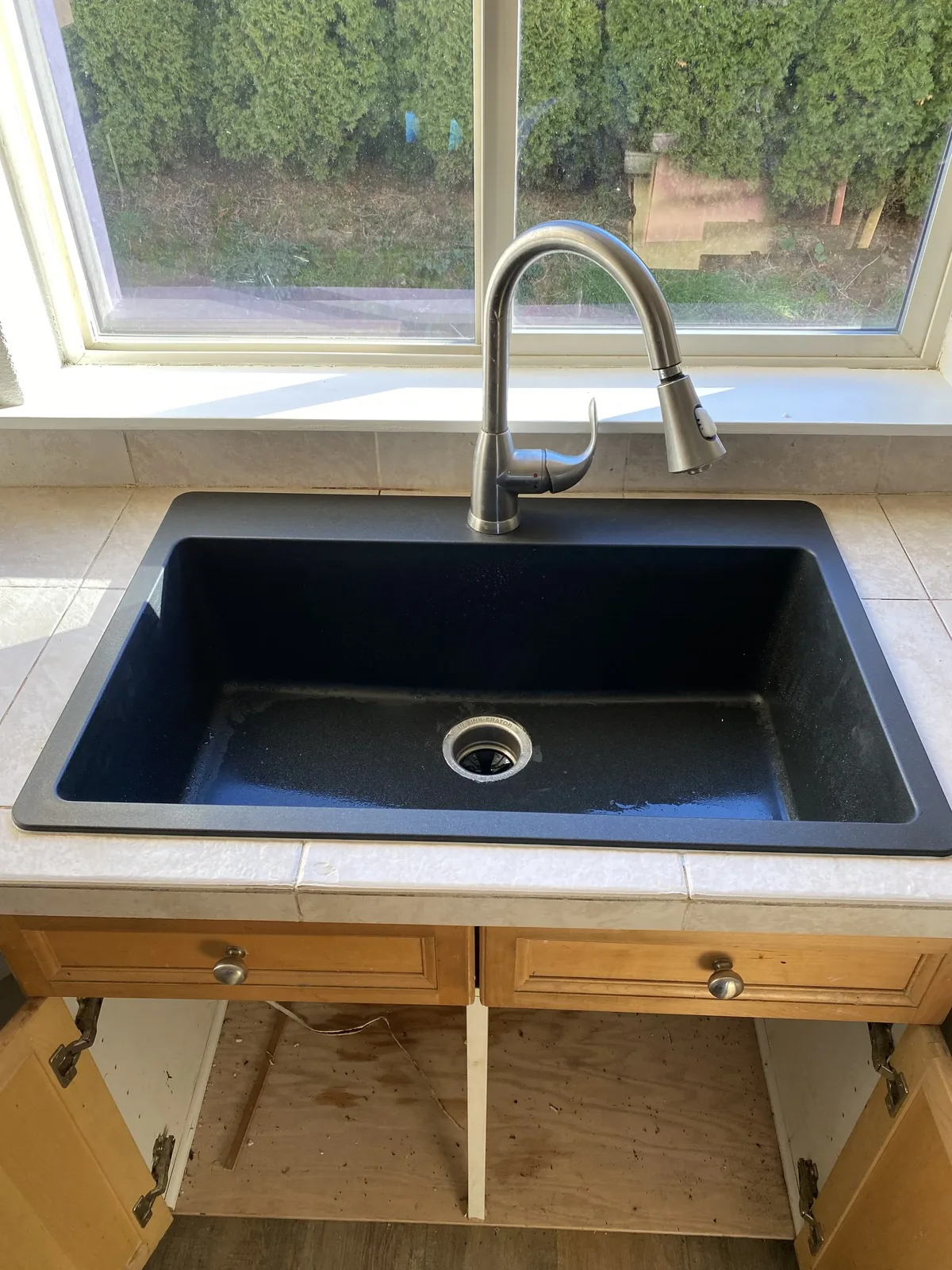 Black granite composite kitchen sink with stainless pull-down faucet