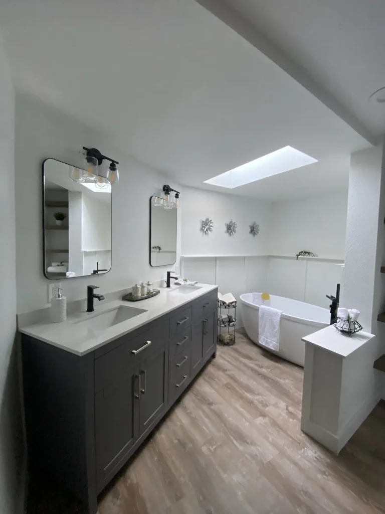 Remodeled primary bathroom with a freestanding soaker tub and double vanity plumbed by Panda Plumbing