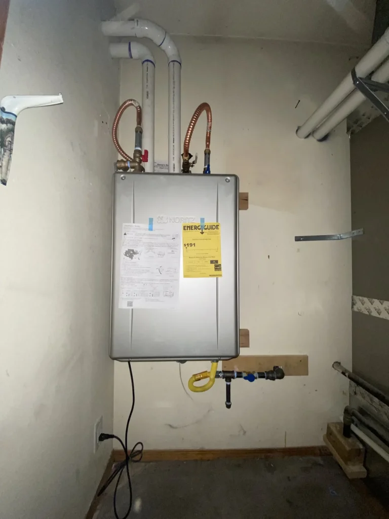 Tankless water heater installed with clean copper connections and proper venting