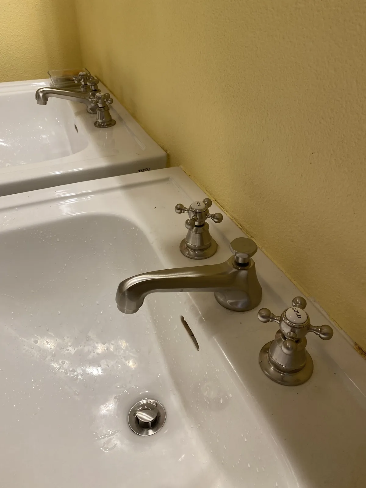 Twin Toto sinks with brushed nickel widespread faucets and porcelain hot and cold cross handles